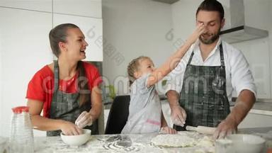 有白人外貌的父母在做饭的时候和他们的女儿在一起很开心。 看上去很有趣。 好心情
